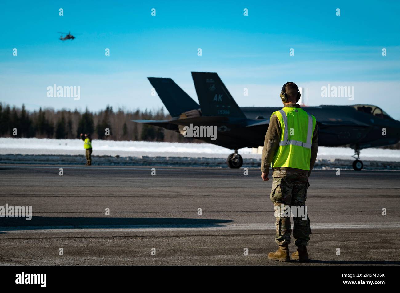NEGLI STATI UNITI Airman marshalls una formazione di 42 F-35A Lightning IIS durante un esercizio di preparazione di routine alla base dell'aeronautica di Eielson, Alaska, 25 marzo 2022. Questa dimostrazione di capacità ha rappresentato il culmine degli sforzi dedicati della 354th Fighter Wing, con ogni Airman che fornisce contributi vitali per garantire la disponibilità del Team Eielson a fornire airpower in qualsiasi momento e ovunque. Foto Stock