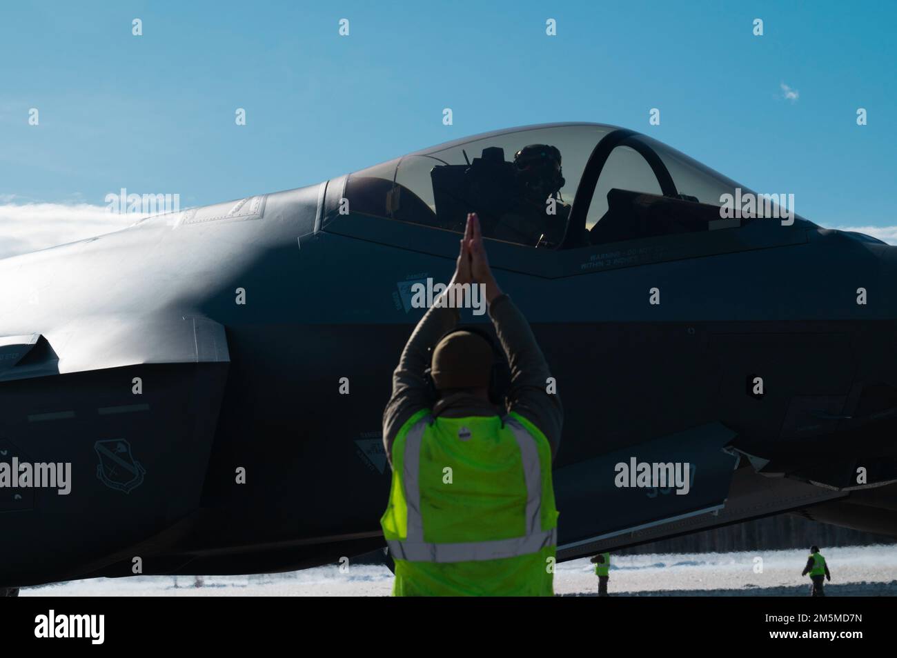 NEGLI STATI UNITI Airman marshalls una formazione di 42 F-35A Lightning IIS durante un esercizio di preparazione di routine alla base dell'aeronautica di Eielson, Alaska, 25 marzo 2022. Questa dimostrazione di capacità ha rappresentato il culmine degli sforzi dedicati della 354th Fighter Wing, con ogni Airman che fornisce contributi vitali per garantire la disponibilità del Team Eielson a fornire airpower in qualsiasi momento e ovunque. Foto Stock