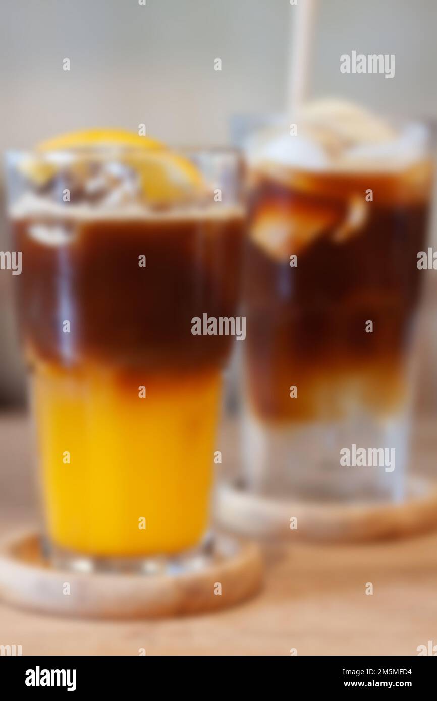 Bicchiere di americano mescolato con sfuocatura di succo d'arancia sfondo, foto di scorta Foto Stock