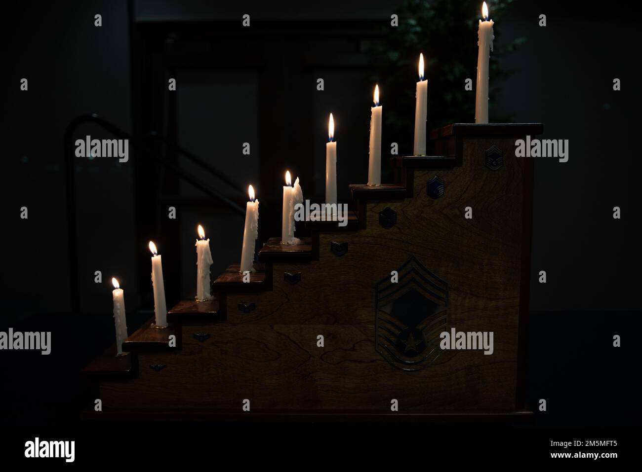 Le candele sono accese su un podio durante la cerimonia di riconoscimento del Capo del Gruppo Holloman, 25 marzo 2022, sulla base dell'aeronautica militare di Holloman, New Mexico. Ogni candela rappresenta un rango che un capomastro sergente deve raggiungere prima di accettare le responsabilità di un capomastro sergente. Foto Stock