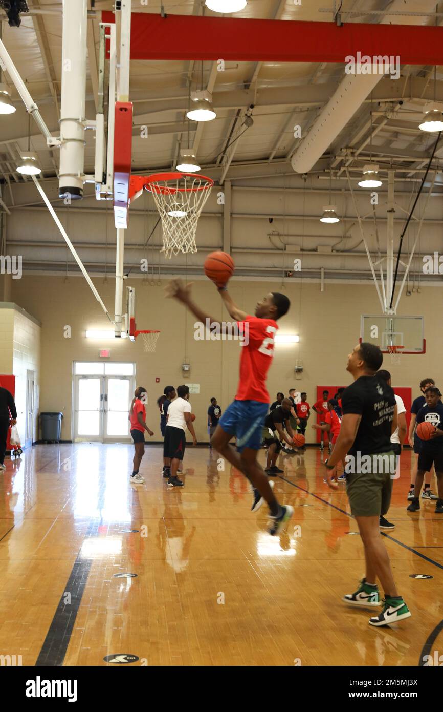 STATI UNITI Marine Chief Warrant Officer 2 Darnell Gervais, Operations Chief for Marine Corps Recruiting Station Montgomery, gioca a basket con un partecipante dei Marine Corps Leaders della clinica di pallacanestro di Hardwood a Montgomery, Alabama, 25 marzo 2022. Lo scopo di questo evento era quello di condurre una clinica di abilità di basket e di offrire un mentorship ai partecipanti. Foto Stock