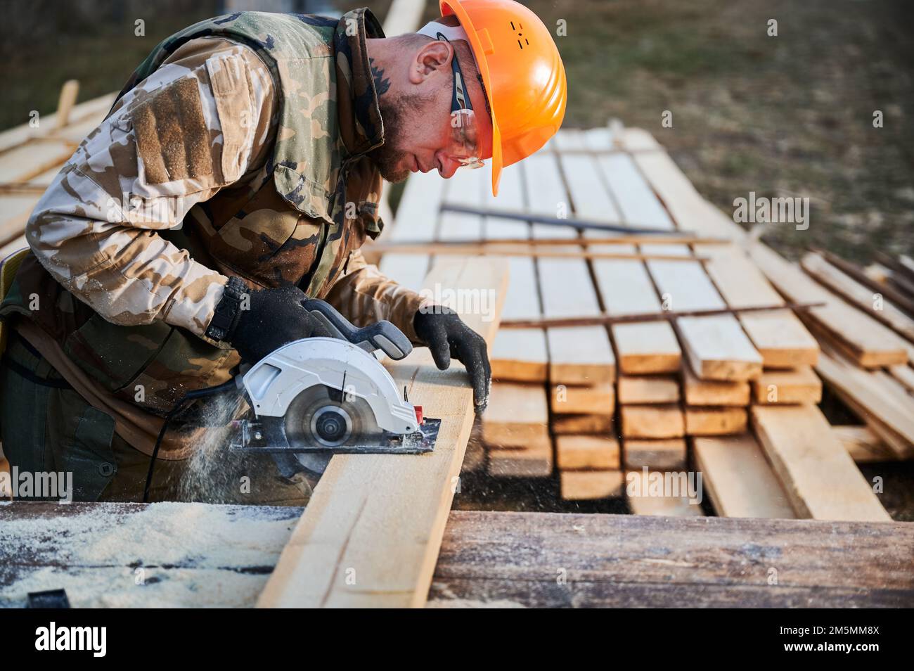 Falegname che usa una sega per legno per tagliare fogli di legno un  falegname con una