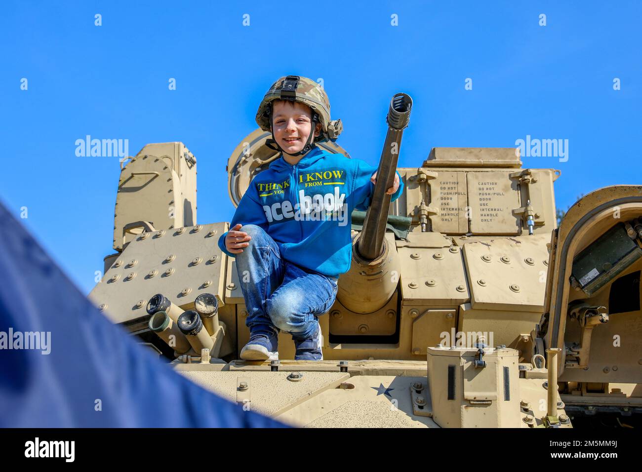 Un bambino polacco posa per una foto su un veicolo da combattimento Bradley M2 durante l’evento “The Great Escape” 10K di Zagan, Polonia, 26 marzo 2022. Soldati della squadra di combattimento della Brigata Armorata 1st, 1st divisione fanteria hanno partecipato a una mostra statica e 10K Memorial Run durante il 78th° anniversario della “Grande fuga”. Foto Stock