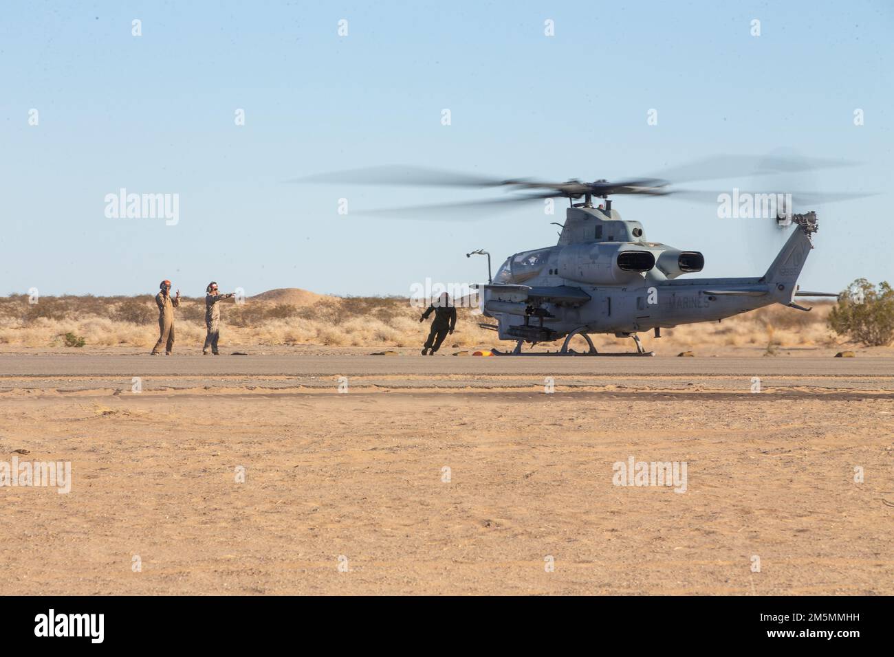 STATI UNITI Gli specialisti del carburante all'ingrosso del corpo marino, assegnati al Marine Aviation Weapons and Tactics Squadron One (MAWTS-1), si avvicinano a un Viper AH-1Z per il rifornimento di carburante presso un punto di armamento e rifornimento (FARP), a sostegno del corso Weapons and Tactics Instructor (WTI) 2-22, presso Auxiliary Airfield II, vicino a Yuma, Arizona, 26 marzo 2022. WTI è un evento di formazione di sette settimane ospitato da MAWTS-1, che fornisce formazione tattica avanzata standardizzata e certificazione delle qualifiche di istruttore di unità per supportare la formazione e la preparazione dell'aviazione marina, e aiuta a sviluppare e utilizzare armi e tattiche per l'aviazione Foto Stock