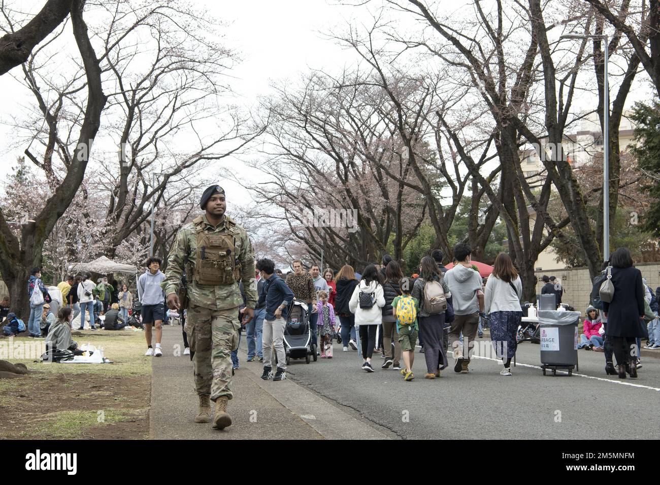 Classe Airman 1st Christopher Thompson, 374th leader della difesa di base delle forze di sicurezza Squadron, cammina lungo McGuire Avenue durante il Sakura Spring Festival 26 marzo 2022, alla base aerea di Yokota, Giappone. Il Sakura Festival è un evento bilaterale volto a rafforzare le relazioni tra Stati Uniti e Giappone. Circa 6.000 membri della comunità off-base sono stati in grado di vedere i ciliegi fioriti, e godere di spettacoli di strada e musica dal vivo accanto alla comunità base, durante l'evento. Foto Stock