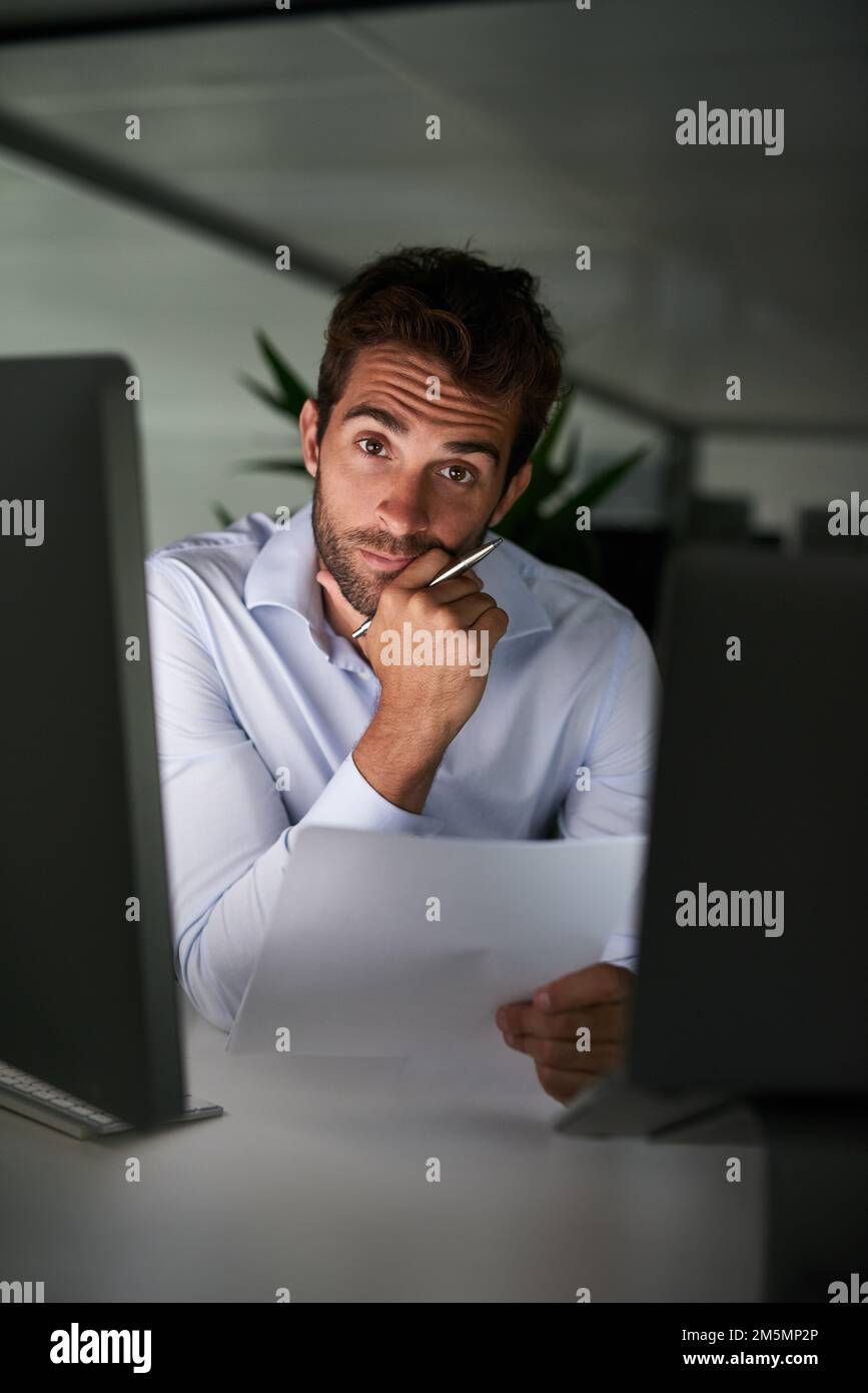 Mettere nelle ore per raggiungere il successo. un giovane uomo d'affari che lavora tardi in ufficio. Foto Stock