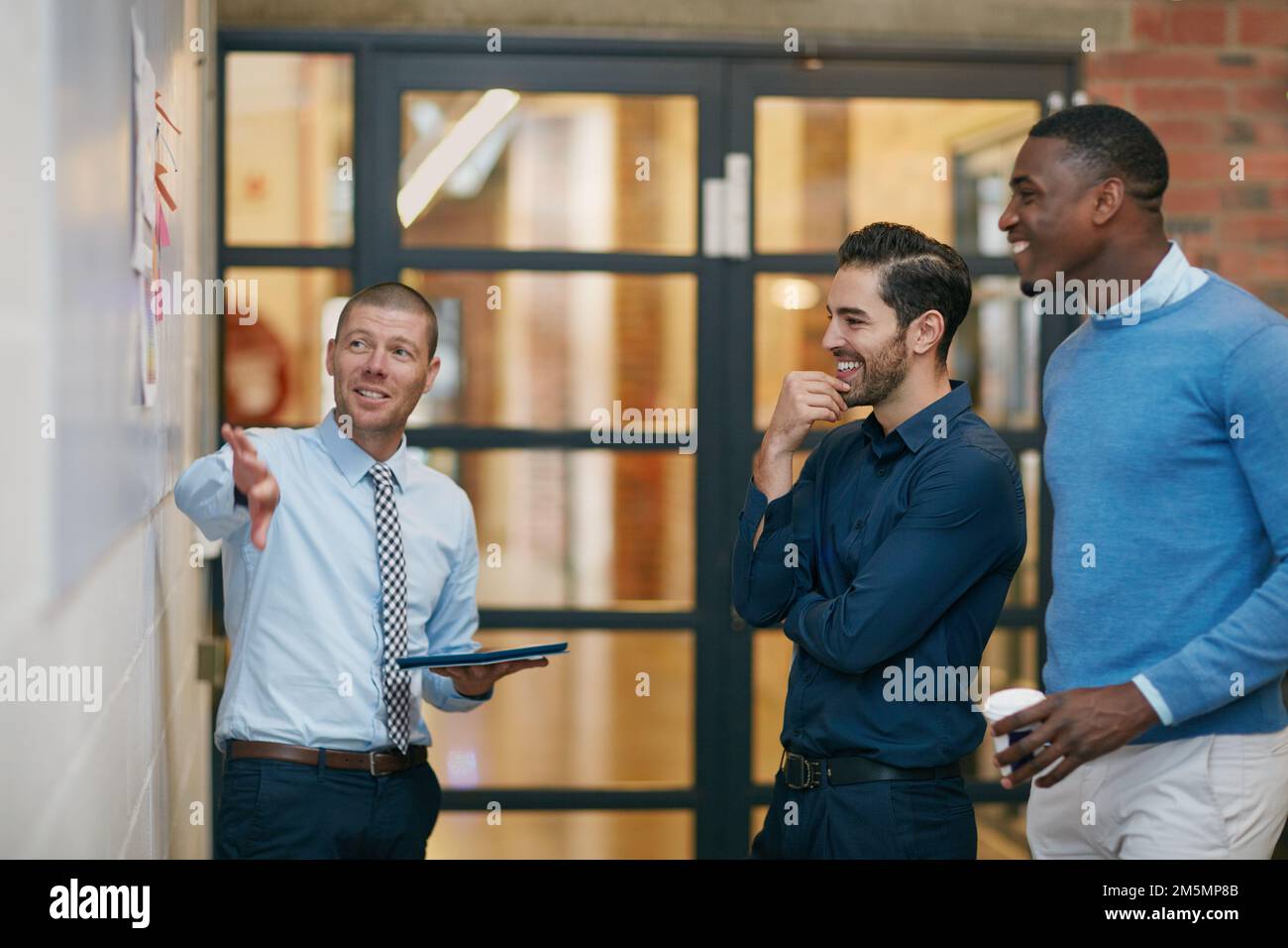 Condividere alcune idee. tre uomini d'affari in ufficio. Foto Stock