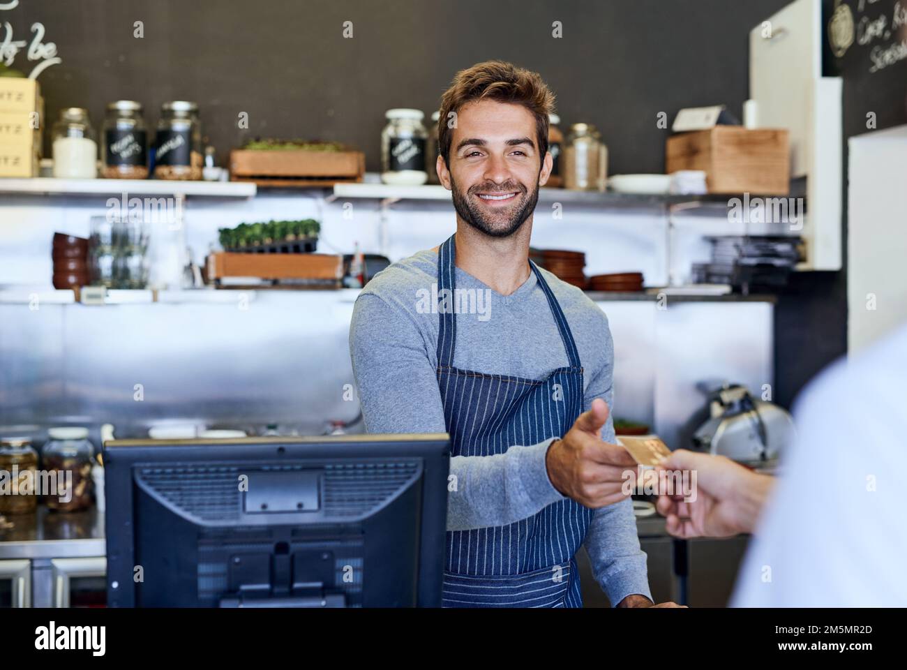 Servizio con un sorriso. un bel giovane uomo d'affari che prende il pagamento da un cliente. Foto Stock