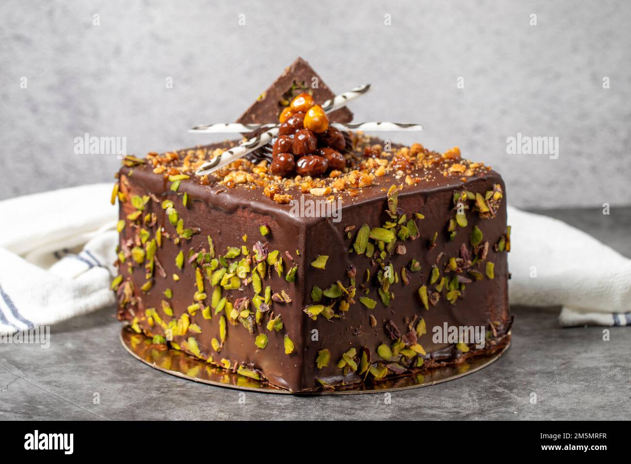 Torta al cioccolato e al pistacchio su fondo scuro. Torta di compleanno o di festa. primo piano Foto Stock