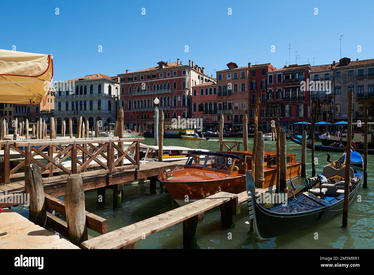 Molo in legno sul Canal Grande a Venezia con taxi e gondole tipici veneziani, Venezia Foto Stock