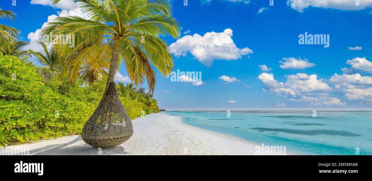 Spiaggia tropicale paradiso panoramico. Paesaggio estivo dell'isola, altalena o amaca sulla palma. Mare sabbia cielo come spiaggia serena. Vacanza panoramica sulla spiaggia di lusso Foto Stock