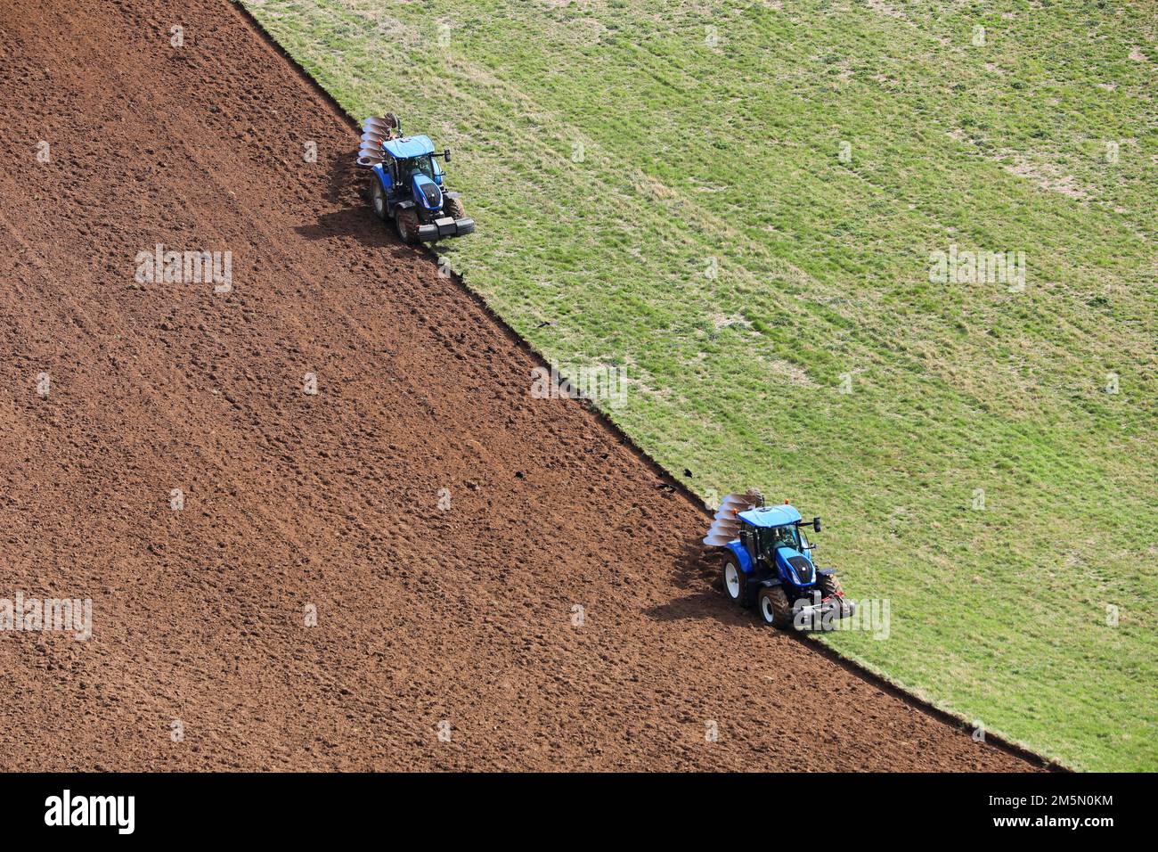 Due trattori raffigurati in agricoltura Goodwood atterrano a Chichester, West Sussex, Regno Unito. Foto Stock