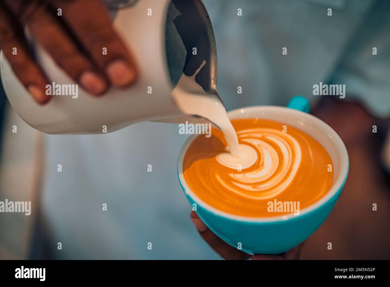Primo piano della caffetteria astratta, caffettiera con caffettiera. Barista che prepara una tazza di caffè latte art. Tonalità vintage alcune persone versano latte per preparare la latte art Foto Stock