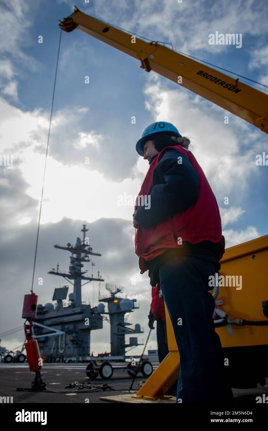 220329-N-EE352-1031 OCEANO PACIFICO (29 marzo 2022) Fire Controlman 2nd Classe Avery Ramey, un nativo di Sedalia, Mo., si prepara a dirigere una gru durante un'operazione di download missilistico sul ponte di volo della portaerei di classe Nimitz USS Carl Vinson (CVN 70), marzo 29. Vinson sta attualmente conducendo operazioni marittime di routine nell'Oceano Pacifico. Foto Stock