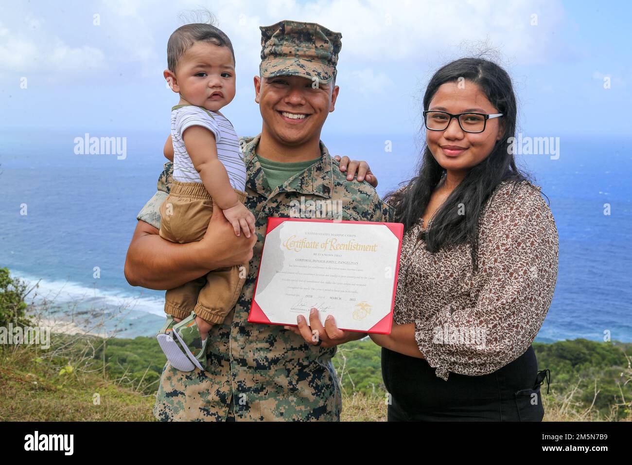 STATI UNITI Donald Pangelinan, allenatore ufficiale non incaricato per la base del corpo dei Marine Camp Blaz, si posa per una foto con sua moglie Tatiana e suo figlio, mentre dopo la sua cerimonia di riascolto al Tarague Overlook sulla base dell'aeronautica Andersen, Guam, 29 marzo 2022. La città natale del caporale Pangelinan è Tanapag, Saipan, ed è laureato alla Marianas High School. Foto Stock