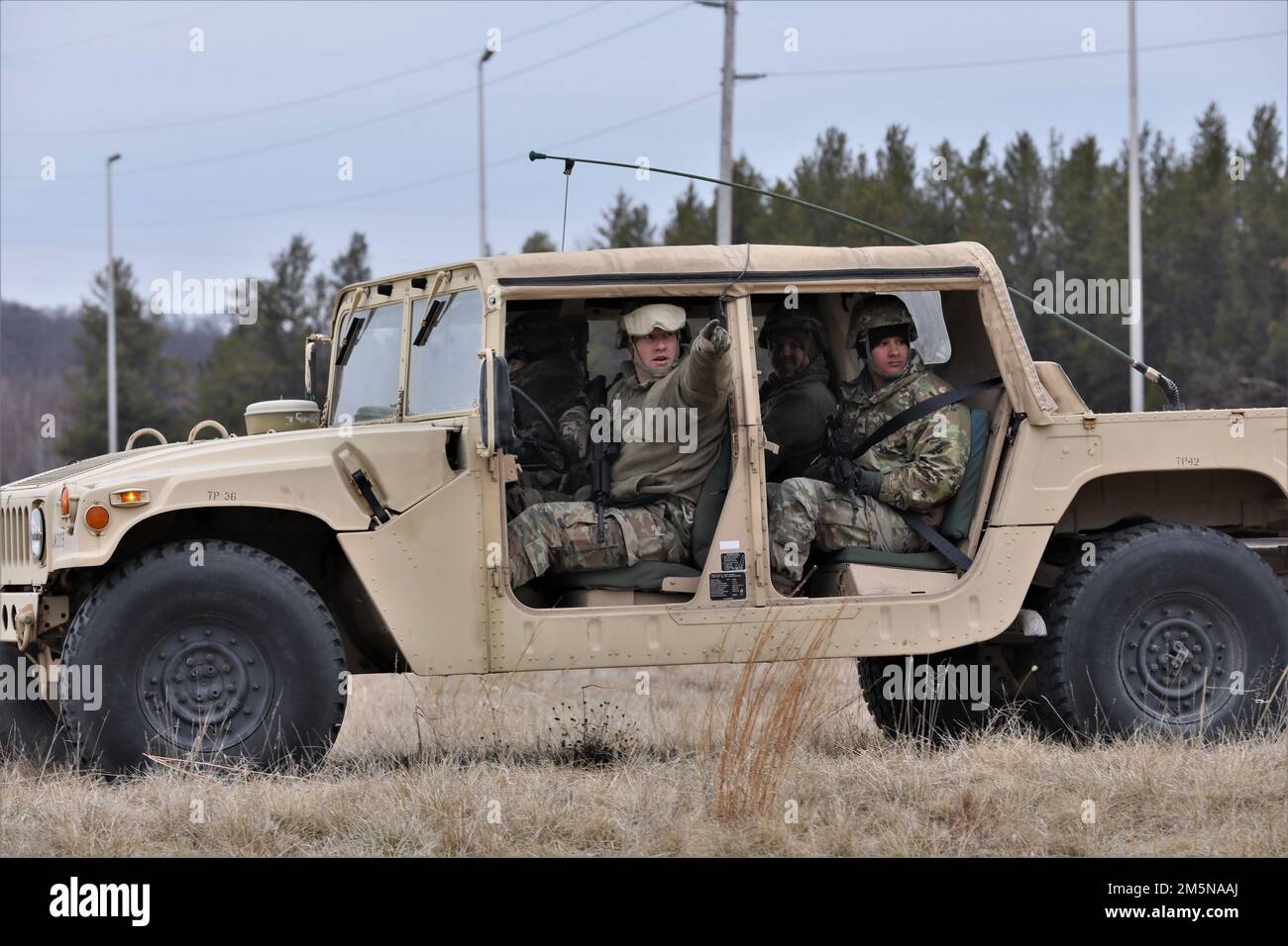 STATI UNITI Lo staff della Riserva dell'esercito Sgt. Dalton Puccio, a sinistra, assegnato alla Compagnia delle Ordnanze del 395th, 103rd comando di sostegno di spedizione, 79th comando di sostegno del teatro, Neenah, Wis., racconta ai suoi compagni soldati, tra cui Sgt. Daniel Arce, a destra, Per osservare la linea del legno mentre esegue una pattuglia itinerante presso un punto di fornitura delle munizioni durante la formazione annuale della società a Fort McCoy, Wisconsin, 29 marzo 2022. Questa formazione individuale e collettiva ha preparato l'azienda a dimostrare la sua disponibilità per la formazione pre-mobilitazione a Fort Hood, Texas. Foto Stock