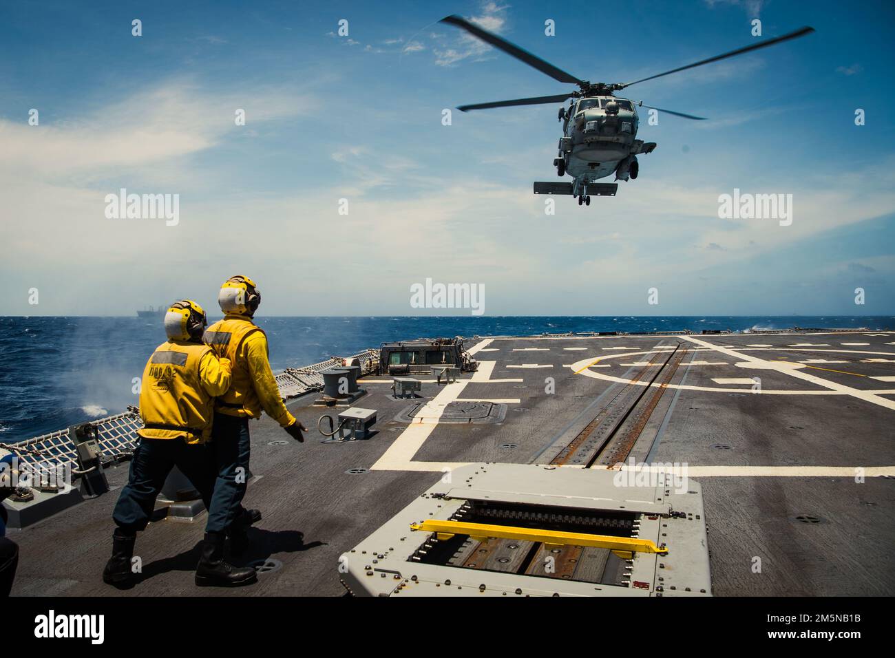 220330-N-TT059-2166 SOUTH CHINA SEA (MAR. 30, 2022) Boatswain's Mate Seaman Keshawn Archer (destra) e Boatswain's Mate 2nd Classe Elisa Sierra (sinistra) inviano segnali manuali a un elicottero MH-60R Sea Hawk dei 'Medici' di Helicopter Maritime Strike Squadron (HSM) 35 durante le operazioni di rifornimento verticale (VERTREP) a bordo del cacciatorpediniere-missile guidato DG MUSS 92). Momsen è assegnato al Comandante, Task Force 71/Destroyer Squadron (DESRON) 15, il più grande DESRON schierato in avanti della Marina e la principale forza di combattimento della flotta degli Stati Uniti 7th, ed è in corso il sostegno di un libero e aperto Indo-P. Foto Stock