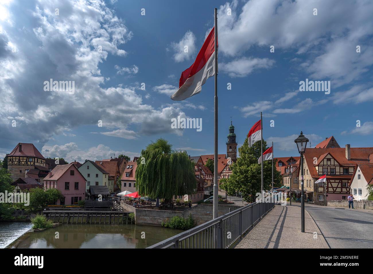 Vista della città vecchia, ponte con bandiere ondulate di fronte, Lauf an der Pegnitz, Franconia media, Baviera, Germania Foto Stock