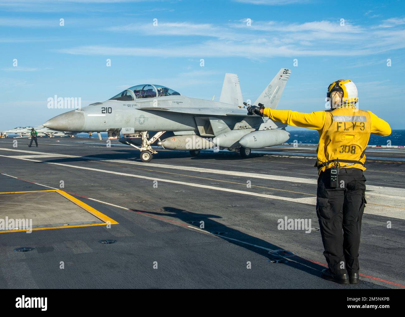 220225-N-MW880-1195 OCEANO ATLANTICO (DAL 25, 2022) Aviation Boatswain’s Mate (Handling) 1st Classe Basir Riddick, assegnato alla portaerei USS George H.W. Bush (CVN 77), dirige un velivolo F/A-18F Super Hornet, attaccato allo Strike Fighter Squadron (VFA) 103, durante il Tailored Ship’s Training Availability/Final Evaluation Problem (TSTA/FEP), febbraio 25. TSTA/FEP è un'evoluzione della formazione multifase progettata per dare all'equipaggio una solida base di competenza operativa a livello di unità e per migliorare la capacità della nave di autoaddestrarsi. George H.W. Bush fornisce l'autorità di comando nazionale flessibile, t Foto Stock