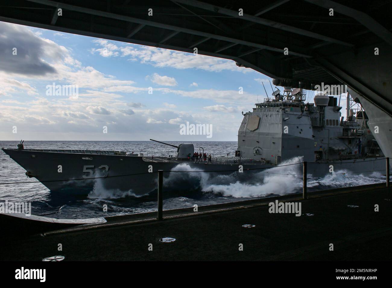MARE DELLE FILIPPINE (26 febbraio 2022) l'incrociatore missilistico guidato di classe Ticonderoga USS Mobile Bay (CG 53) conduce un rifornimento in mare con la portaerei di classe Nimitz USS Abraham Lincoln (CVN 72). Abraham Lincoln Strike Group è in fase di implementazione pianificata nell'area delle operazioni della flotta 7th degli Stati Uniti per migliorare l'interoperabilità attraverso alleanze e partnership e al tempo stesso fungere da forza di risposta pronta a sostegno di una regione indomPacifico libera e aperta. Foto Stock