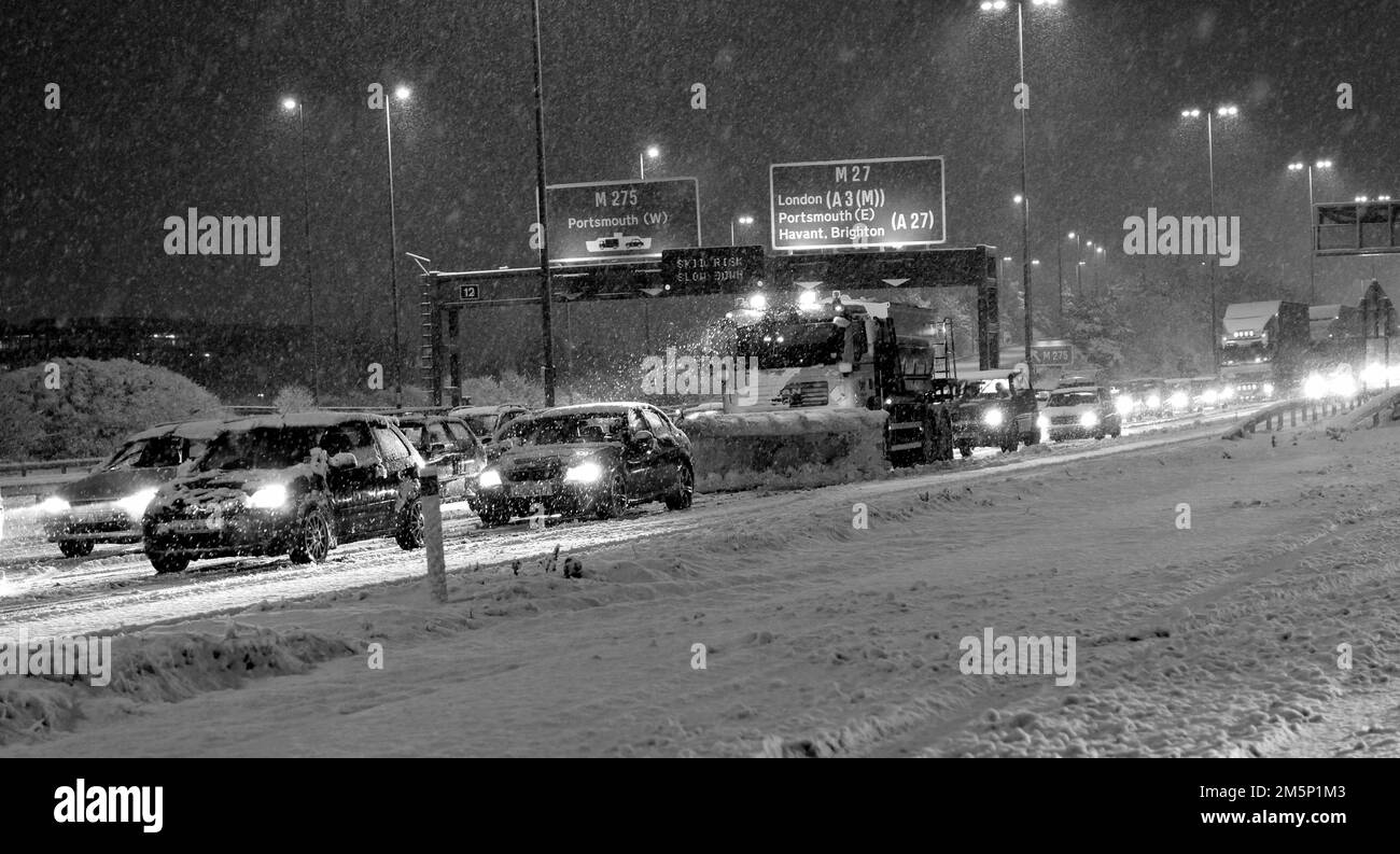 Neve pesante che cade sul M27 di notte con i veicoli gritting che lottano per far fronte, M27, vicino a Portsmouth, Hampshire, Inghilterra, REGNO UNITO Foto Stock