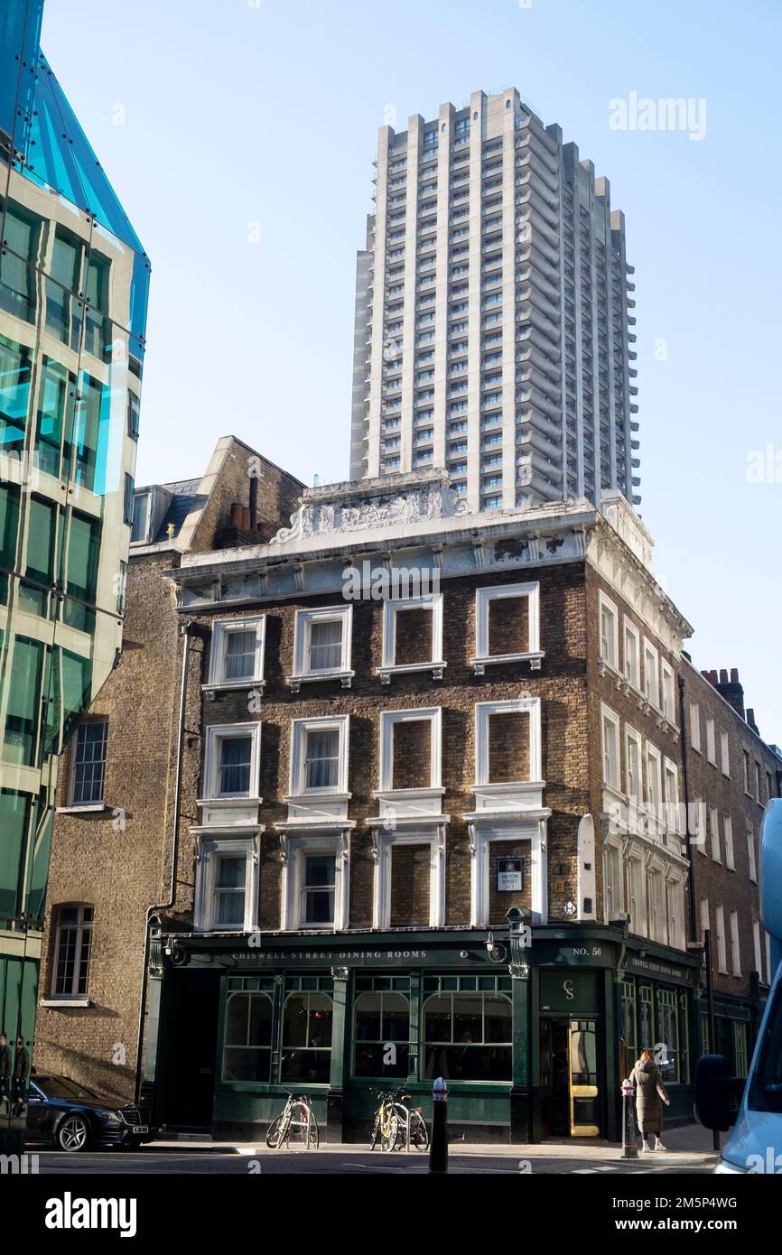 Vista della torre barbicana Defoe House che sorge sopra Chiswell Street Dining Rooms e vecchi edifici della città nuova contrasto a Londra EC1 Inghilterra KATHY DEWITT Foto Stock