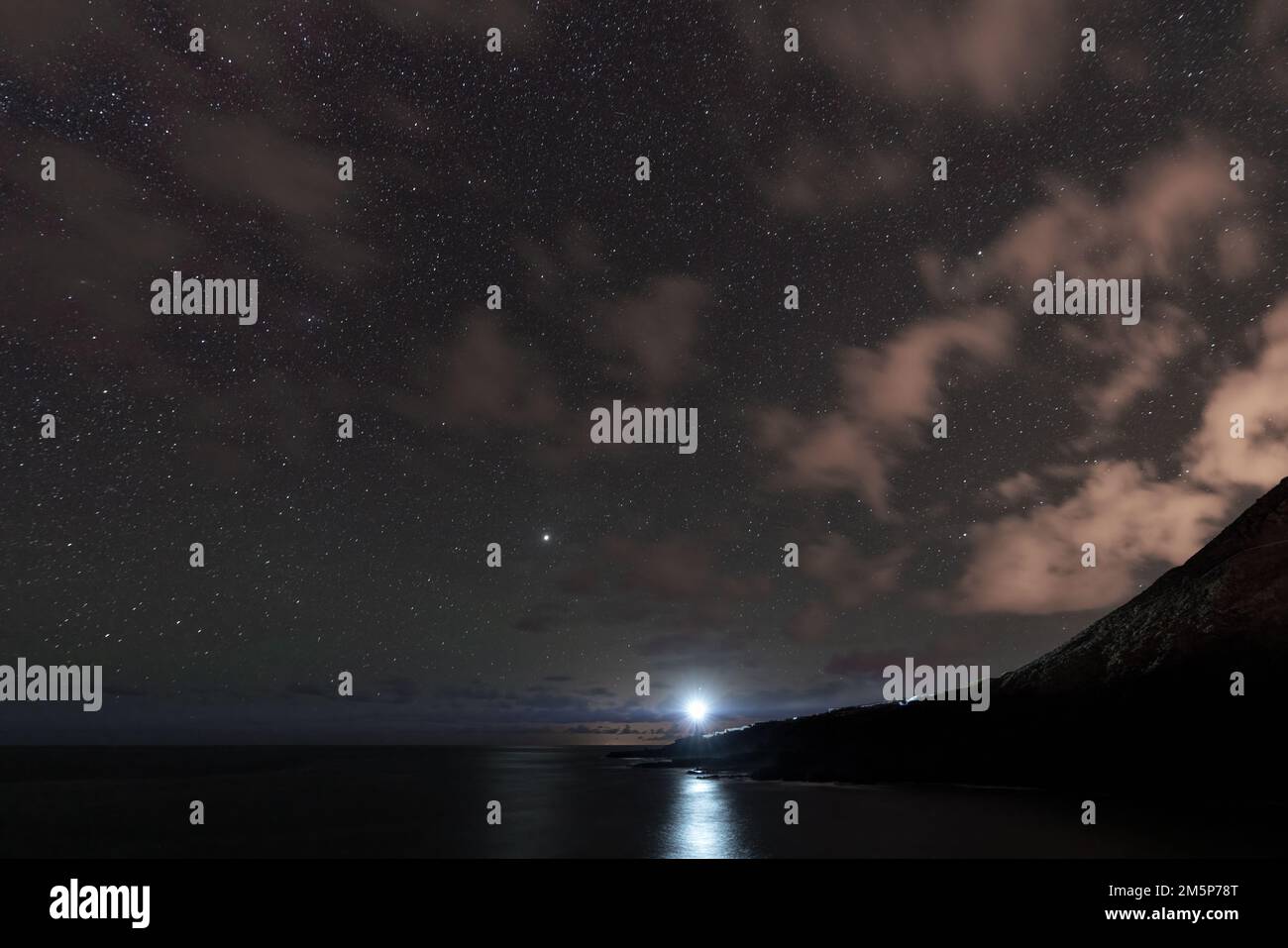 Faro e l'oceano di notte con le nuvole Foto Stock