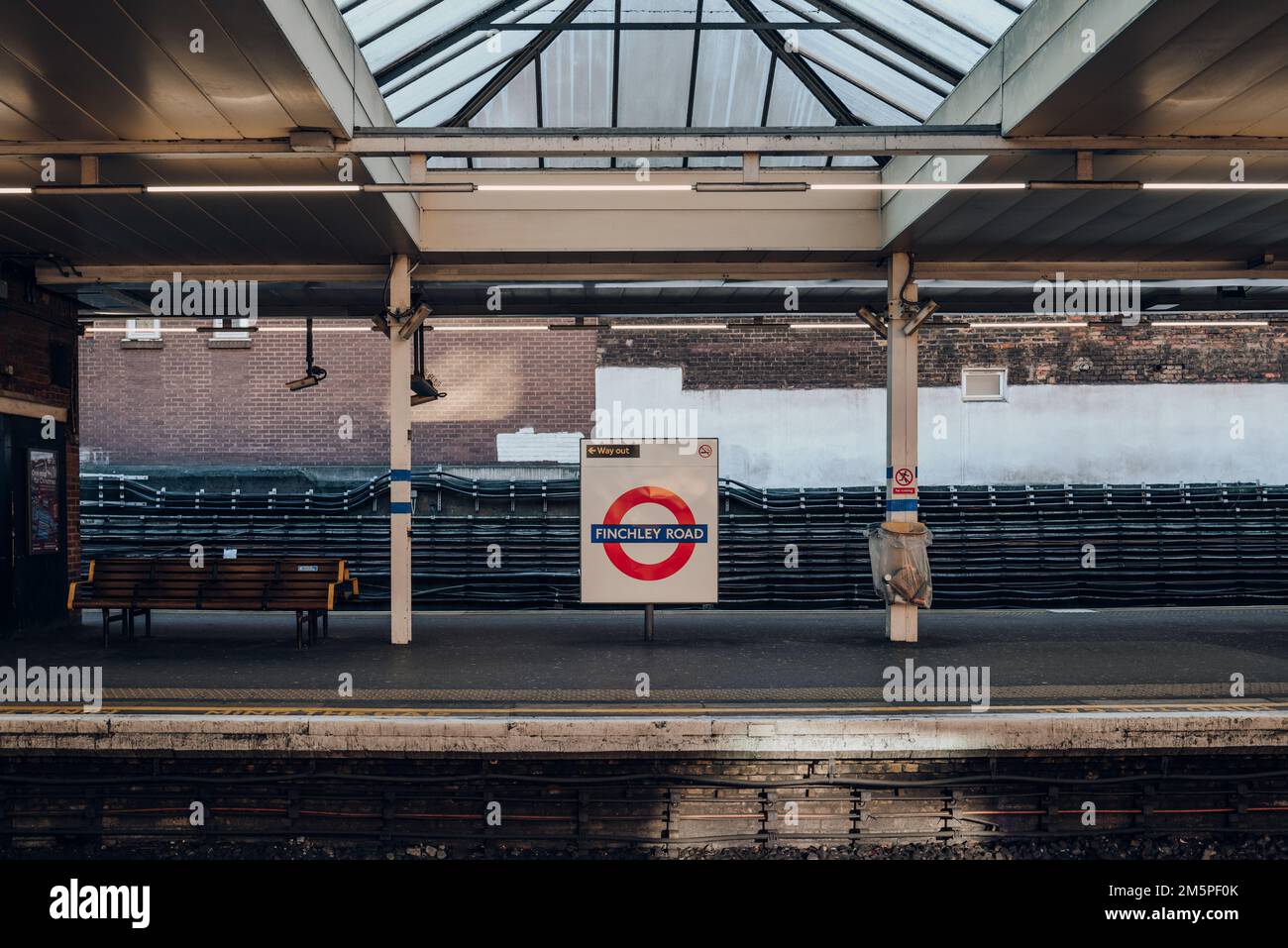 Londra, Regno Unito - 26 dicembre 2022: Cartello con il nome di un roundel sulla piattaforma esterna della stazione Finchley Road della metropolitana di Londra, la più vecchia ferrovia sotterranea Foto Stock