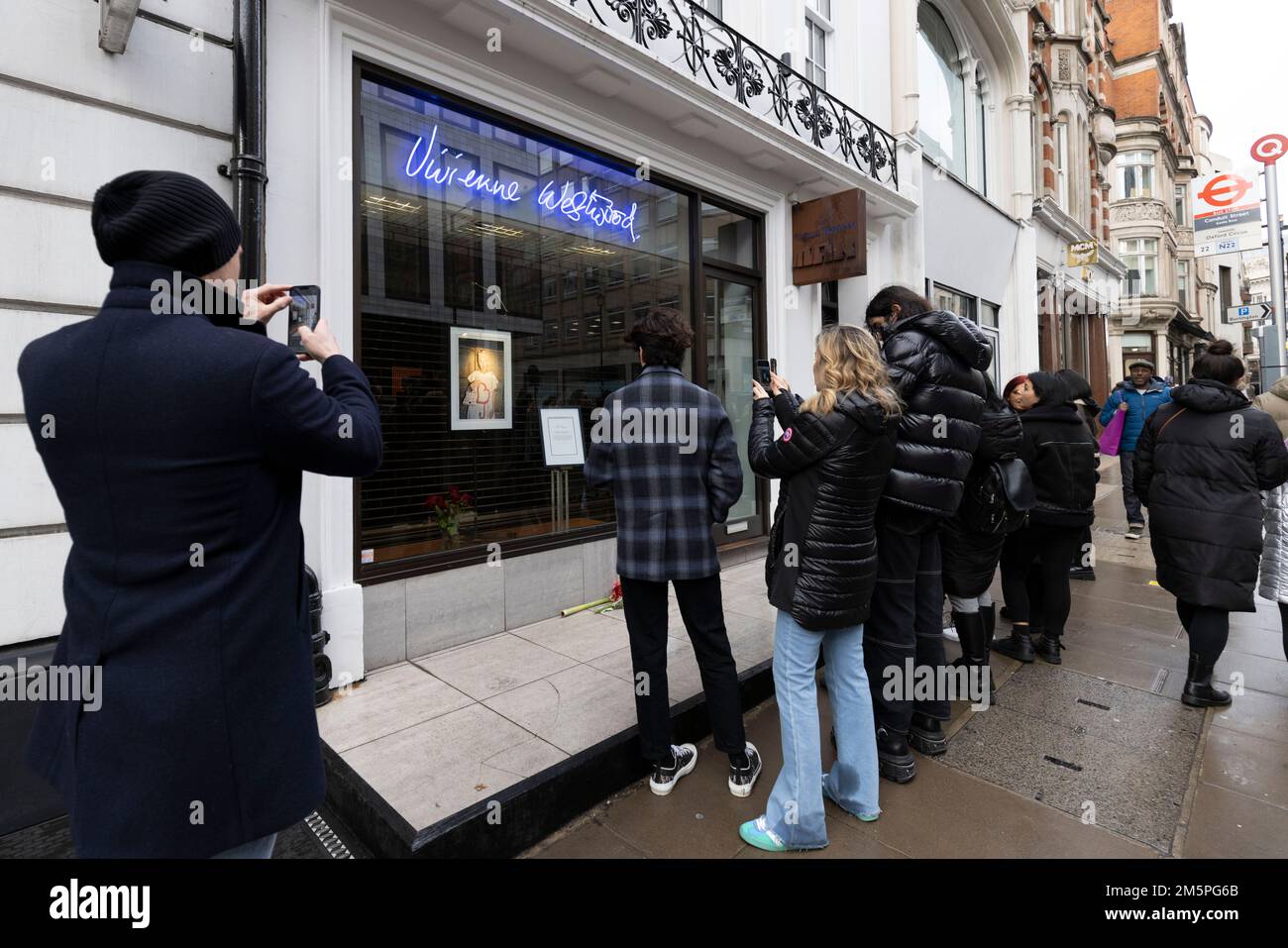 La gente guarda un tributo al negozio di punta Vivienne Westwood a Londra, il fashion designer è morto all'età di 81 anni. Data immagine: Venerdì 30 dicembre 2022. Foto Stock