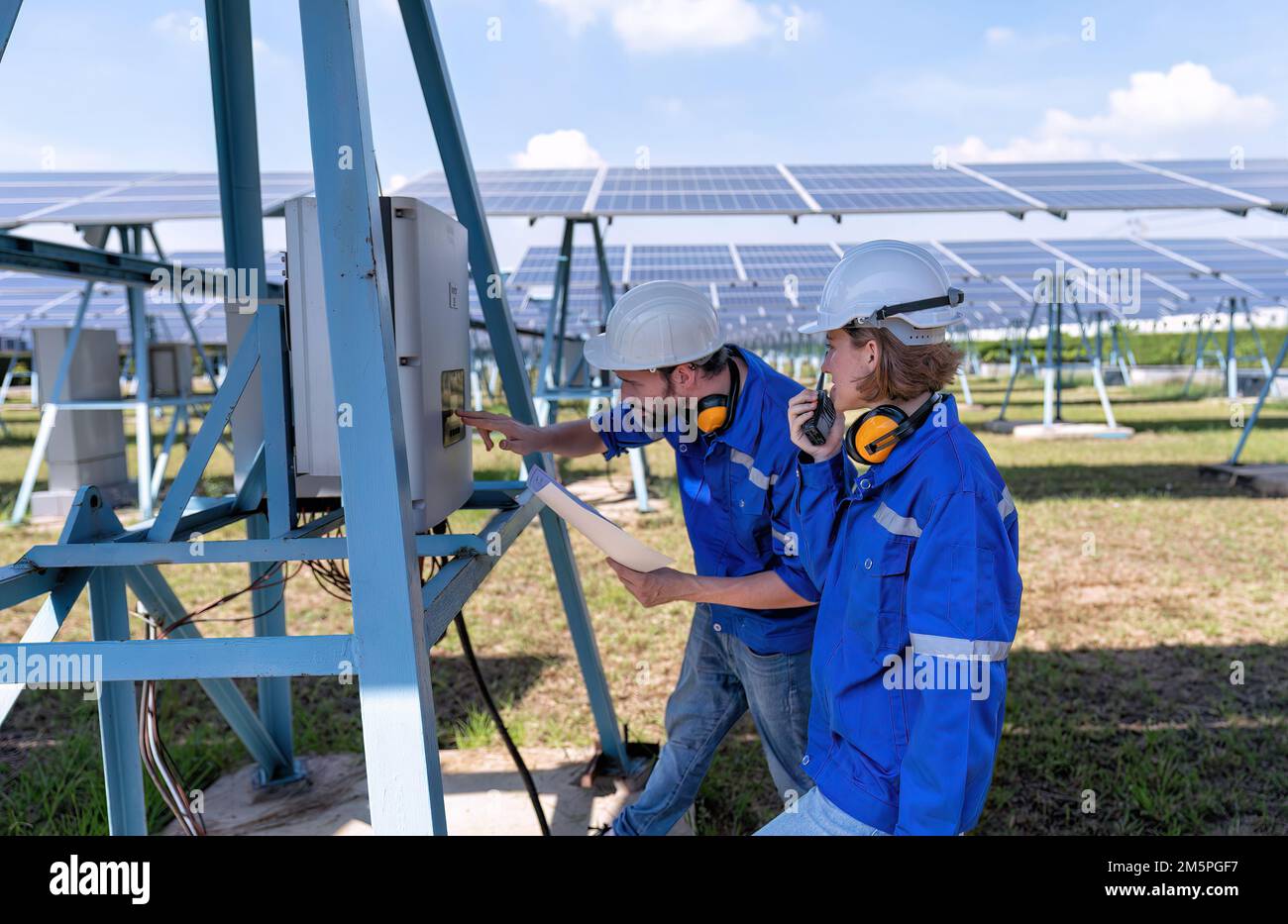 Tecnico addetto alla manutenzione presso la centrale solare per la risoluzione dei problemi relativi al malfunzionamento del pannello di controllo dell'inverter Foto Stock