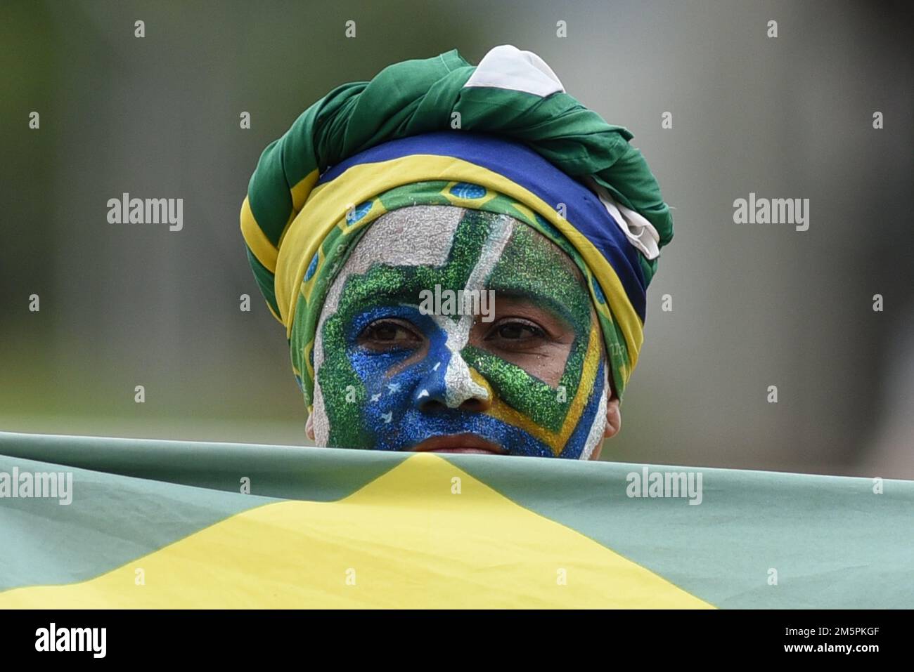 Brasília, DF - 30.12.2022: BOLSONARISTAS ACOMPANHAM LIVE NO ALVORADA - foto di supporto con volto dipinto e recante la bandiera brasiliana. Questo venerdì (30) il presidente Jair Bolsonaro ha salutato Live e i sostenitori che erano a Palácio da Alvorada hanno seguito, pianto e alcune maledizioni al presidente dopo la fine della pronuncia. (Foto: Ton Molina/Fotoarena) Foto Stock