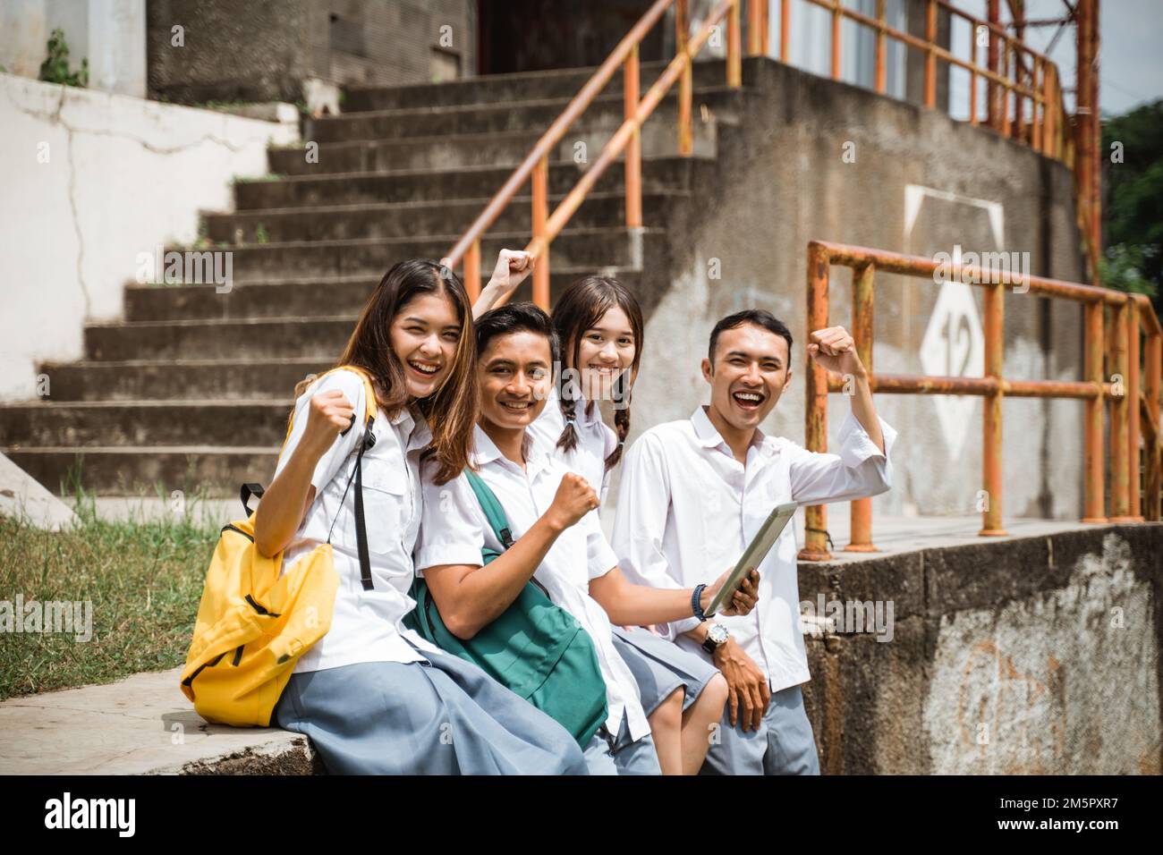 Allievo eccitato della scuola superiore con i pugni che guardano la macchina fotografica Foto Stock