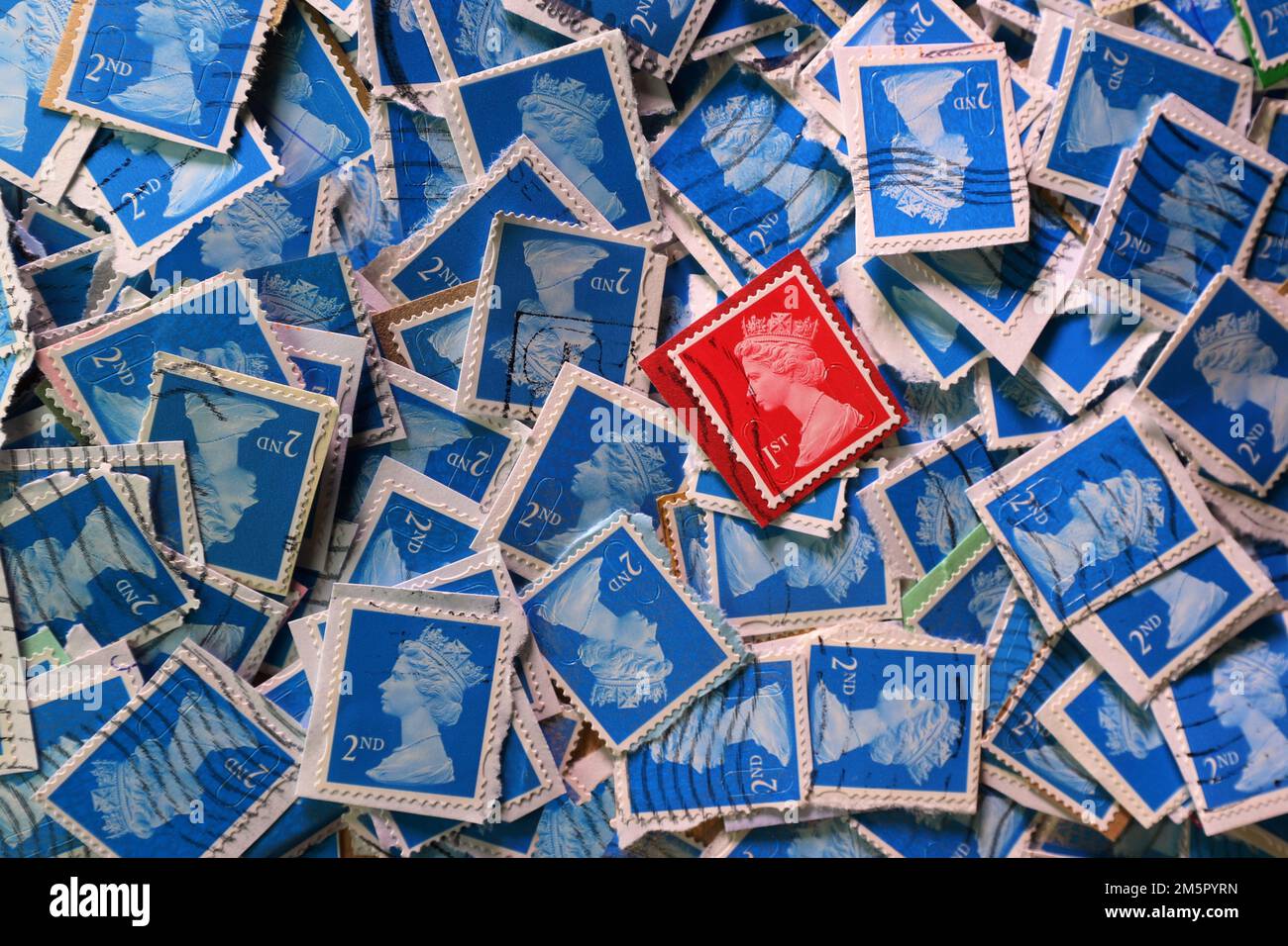 Usato UK franked francobolli di affrancatura che sono collectd per un contributo di carità. Una selezione colorata di francobolli di uso Royal Mail britannici in primo piano. Regno Unito. Timbro rosso di prima classe (1st) su uno sfondo dei timbri blu di seconda classe (2nd) Foto Stock
