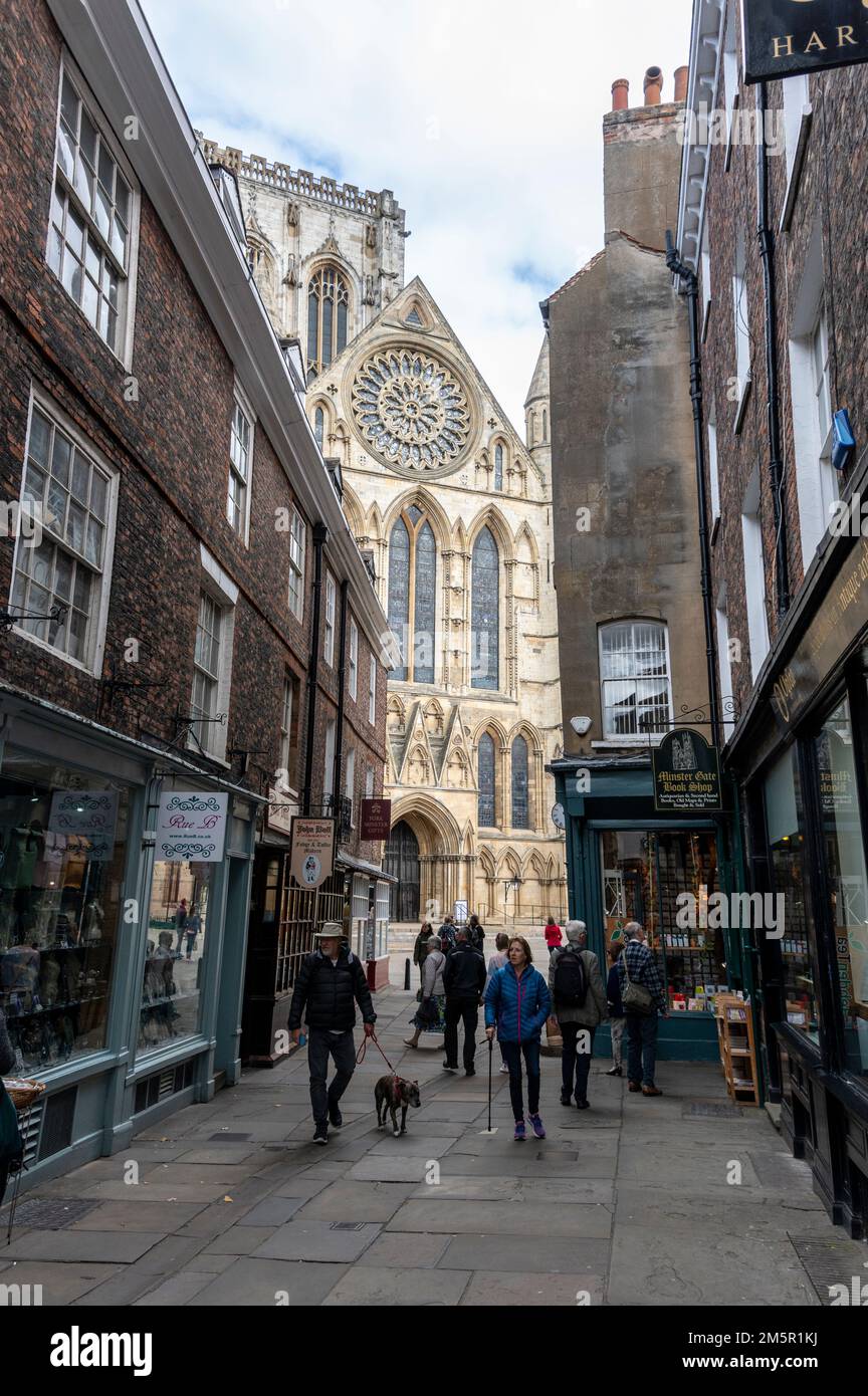 Una stretta strada pedonale-libera-Minster Gate che conduce verso York Minster nella città vecchia di York in Yorkshire, Gran Bretagna Foto Stock