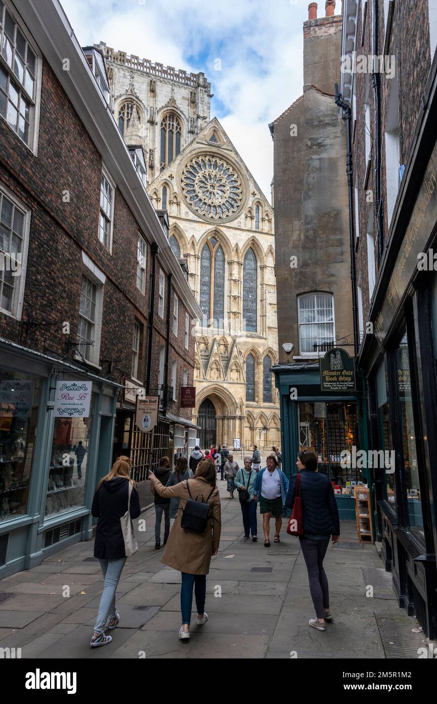 Una stretta strada pedonale-libera-Minster Gate che conduce verso York Minster nella città vecchia di York in Yorkshire, Gran Bretagna Foto Stock