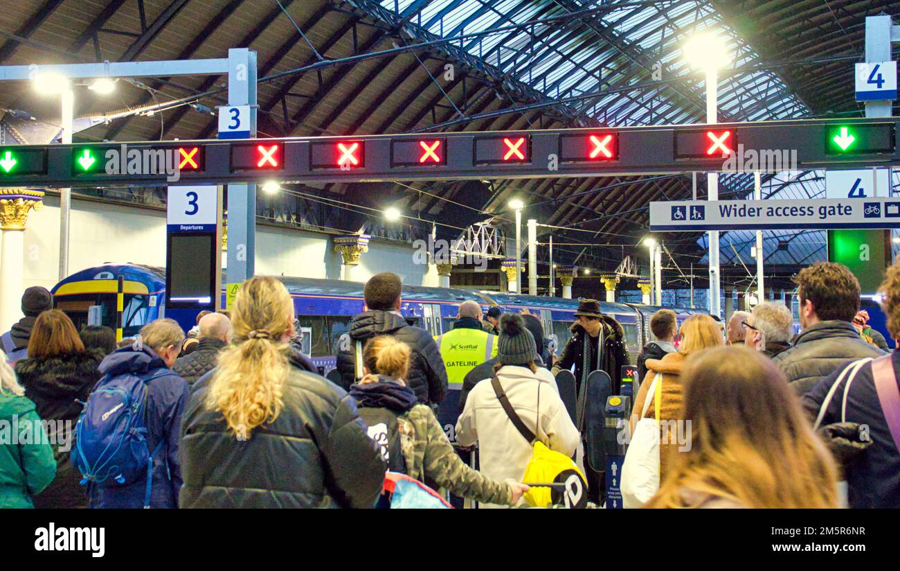 Glasgow, Scozia, Regno Unito 30th dicembre 2022. UK Weather: La pioggia colpisce i treni e le grandi folle di passeggeri che guardano le tavole ansiosamente nella stazione di Queen Street . Credit Gerard Ferry/Alamy Live News Foto Stock