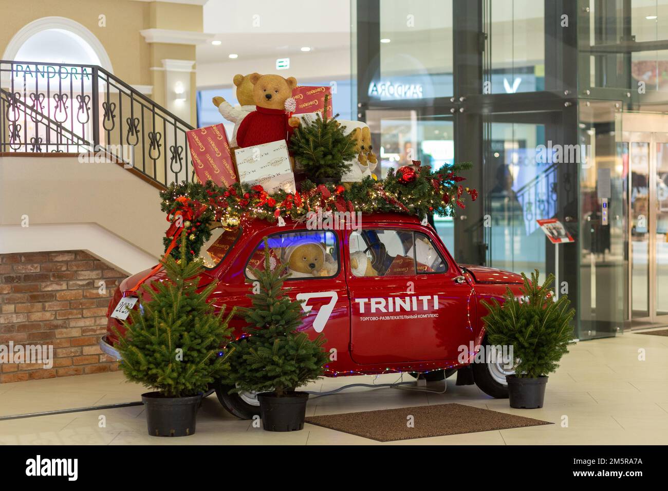 Grodno, Bielorussia - 11 dicembre 2022: Auto retrò decorato con luci festive di Capodanno, ghirlande, rami di alberi di Natale, scatole da regalo in multivalor Foto Stock