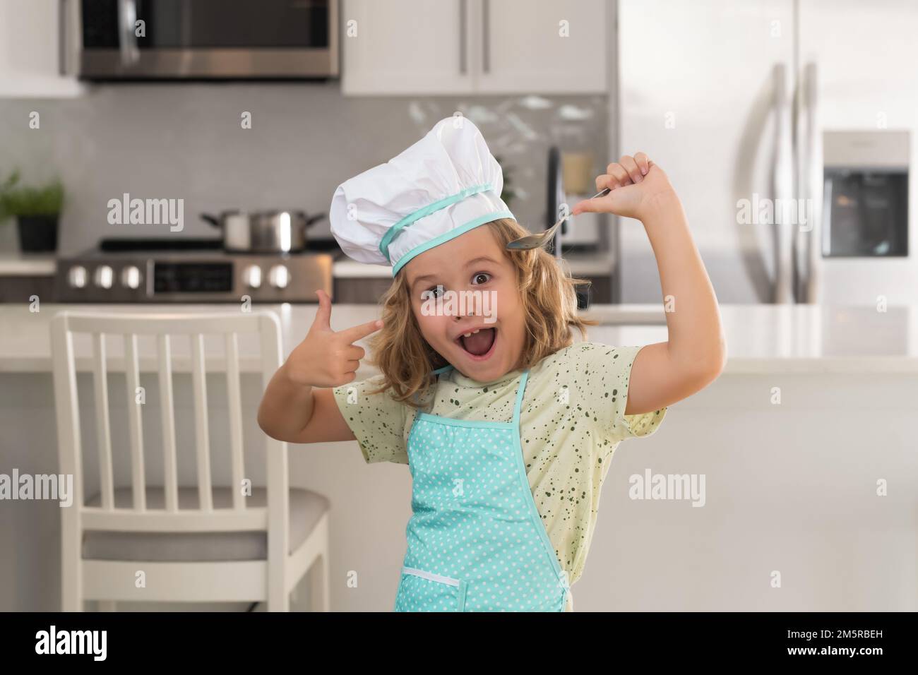 Il cuoco del cuoco del bambino prepara il cibo alla cucina. Cucina per  bambini. Ragazzo con grembiule e cappello da chef che prepara un pasto sano  Foto stock - Alamy