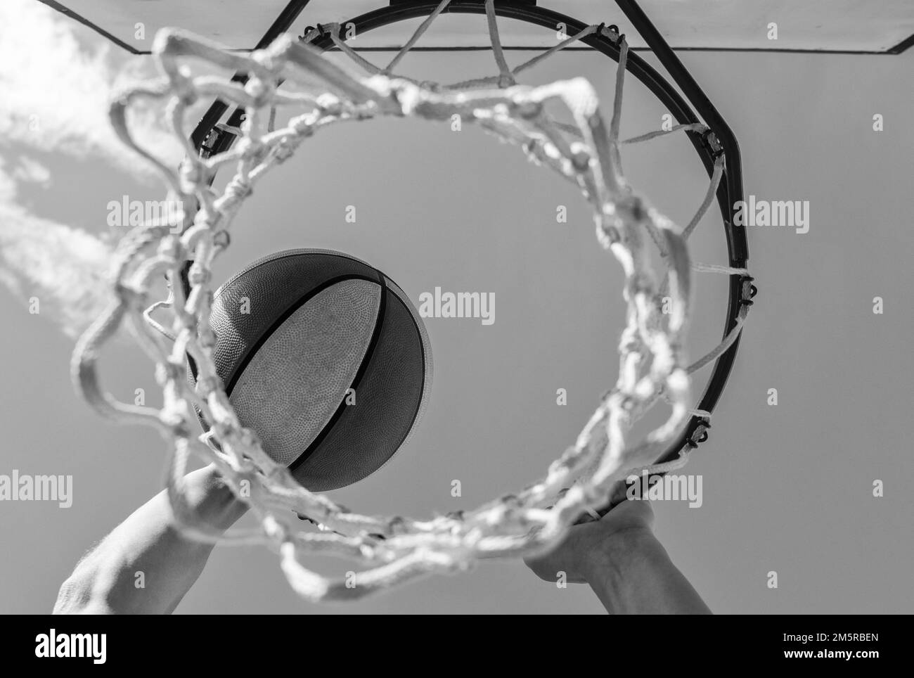 punteggio durante il basket. la palla passa attraverso il cestino. l'uomo che getta la palla in cerchio. Foto Stock