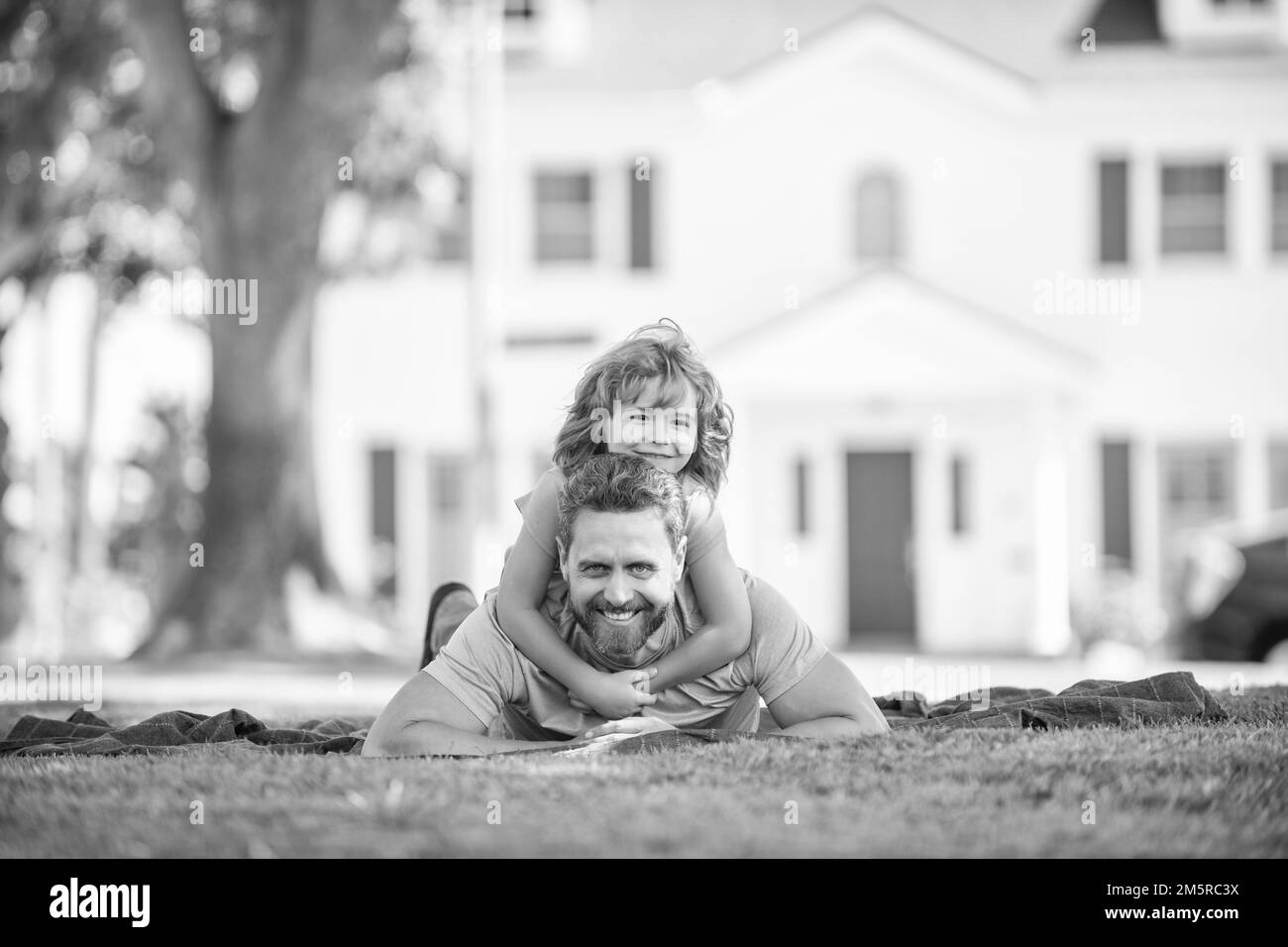 felice padre divertirsi con il bambino rilassarsi insieme sul verde parco erba, amici Foto Stock