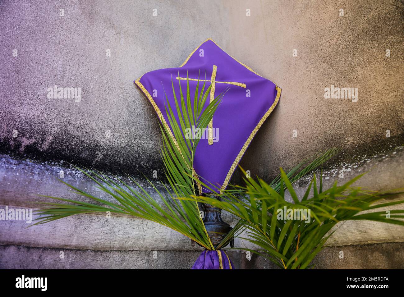 Settimana Santa. Croce ricoperta di tessuto viola nel periodo di Quaresima. Celebrazione cattolica tradizionale Domenica delle Palme. Fede cristiana. Simbolo religioso. Foto Stock