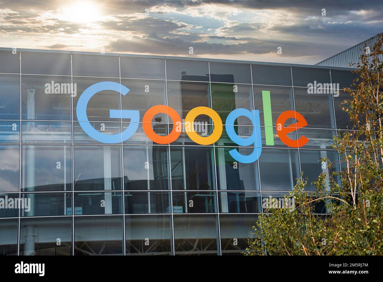 Facciata del moderno ufficio di google con logo colorato durante il tramonto Foto Stock