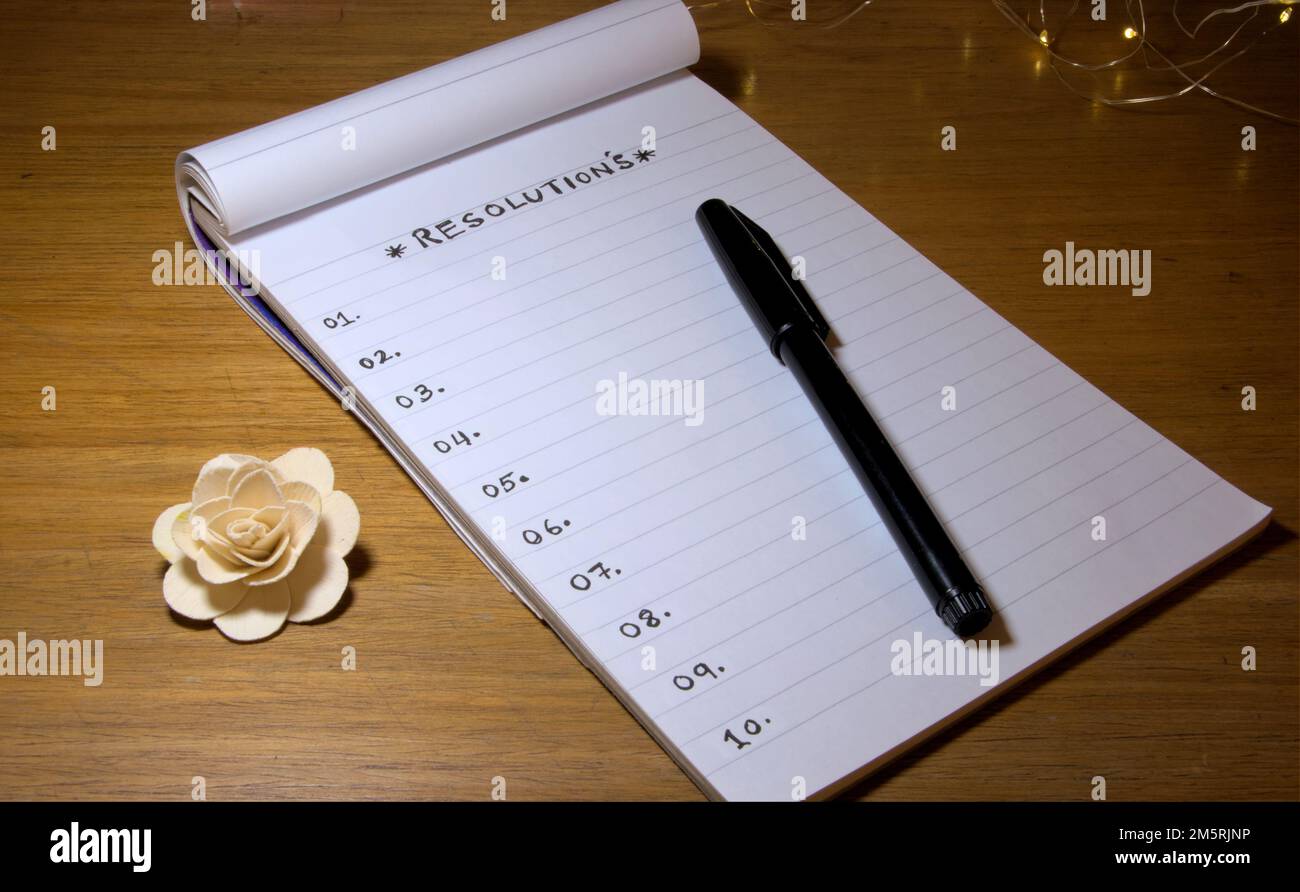 RISOLUZIONE scritta su un blocco note o un libro con una penna sul tavolo. Foto Stock