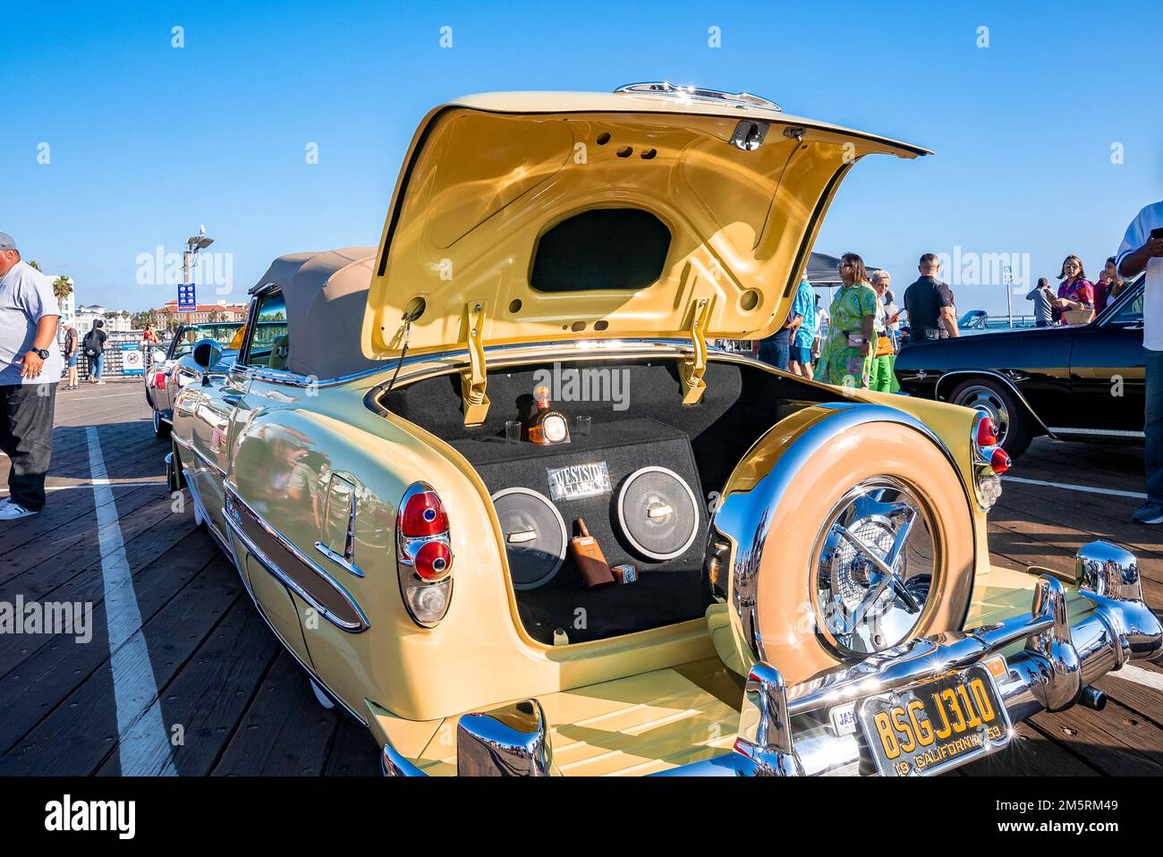 Auto d'epoca gialla con altoparlante retro e telecomando nel bagagliaio al salone Foto Stock