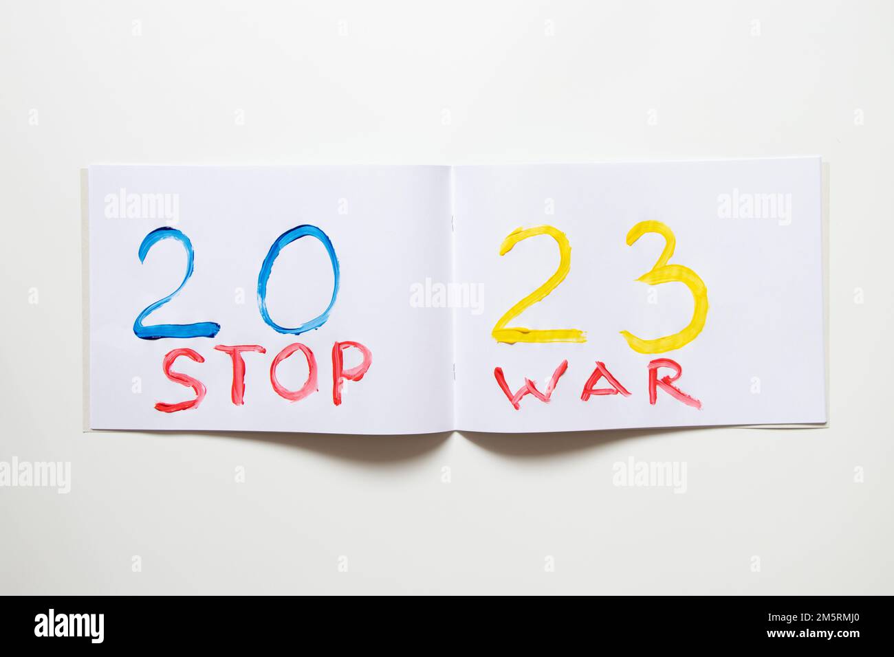 2023 è dipinto con colori giallo e blu nel colore della bandiera dell'Ucraina su un album bianco su sfondo bianco e il testo STOP War, Happy NE Foto Stock