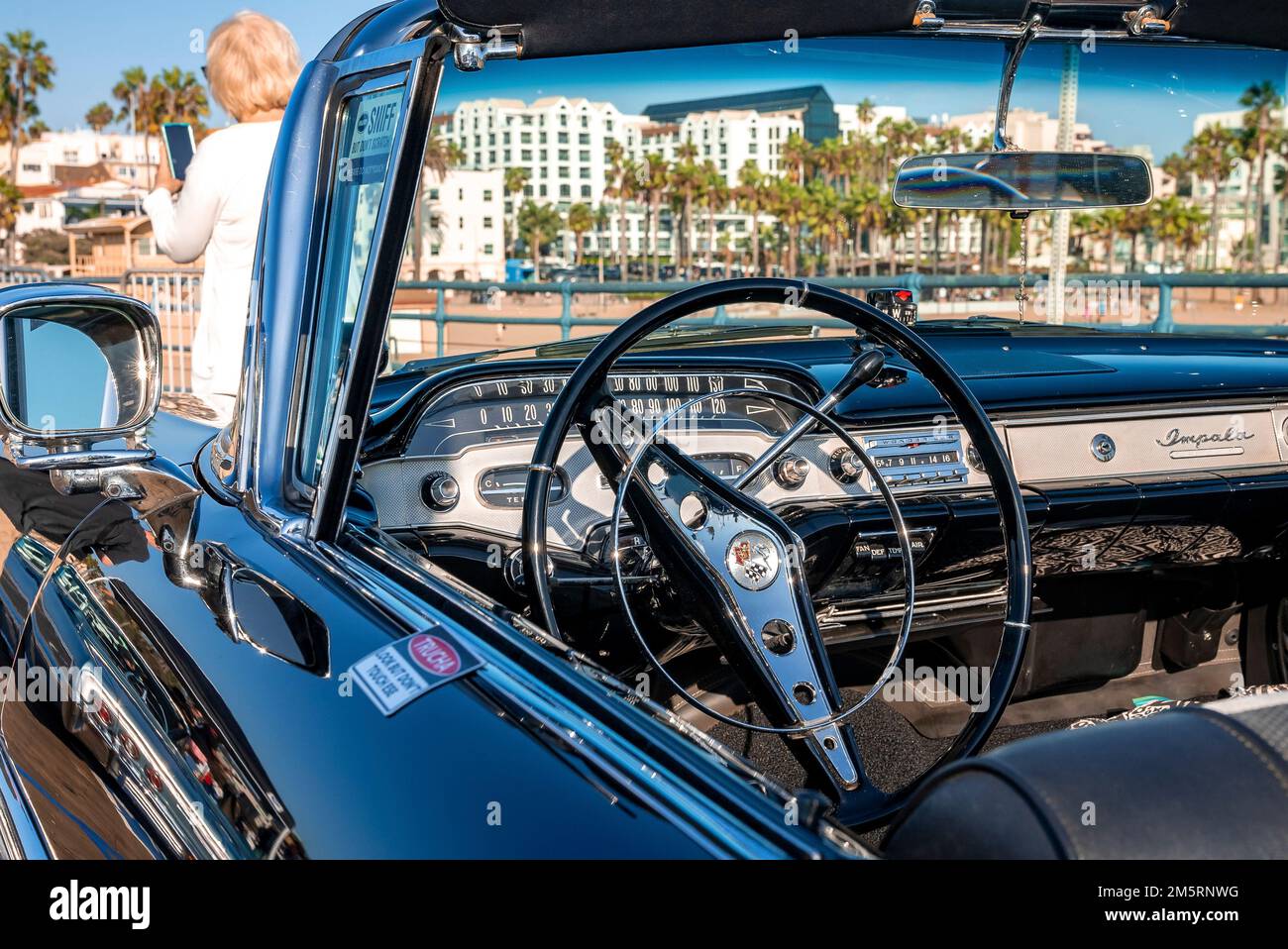 Primo piano del volante in un'auto convertibile retro-nera esposta al salone delle auto Foto Stock