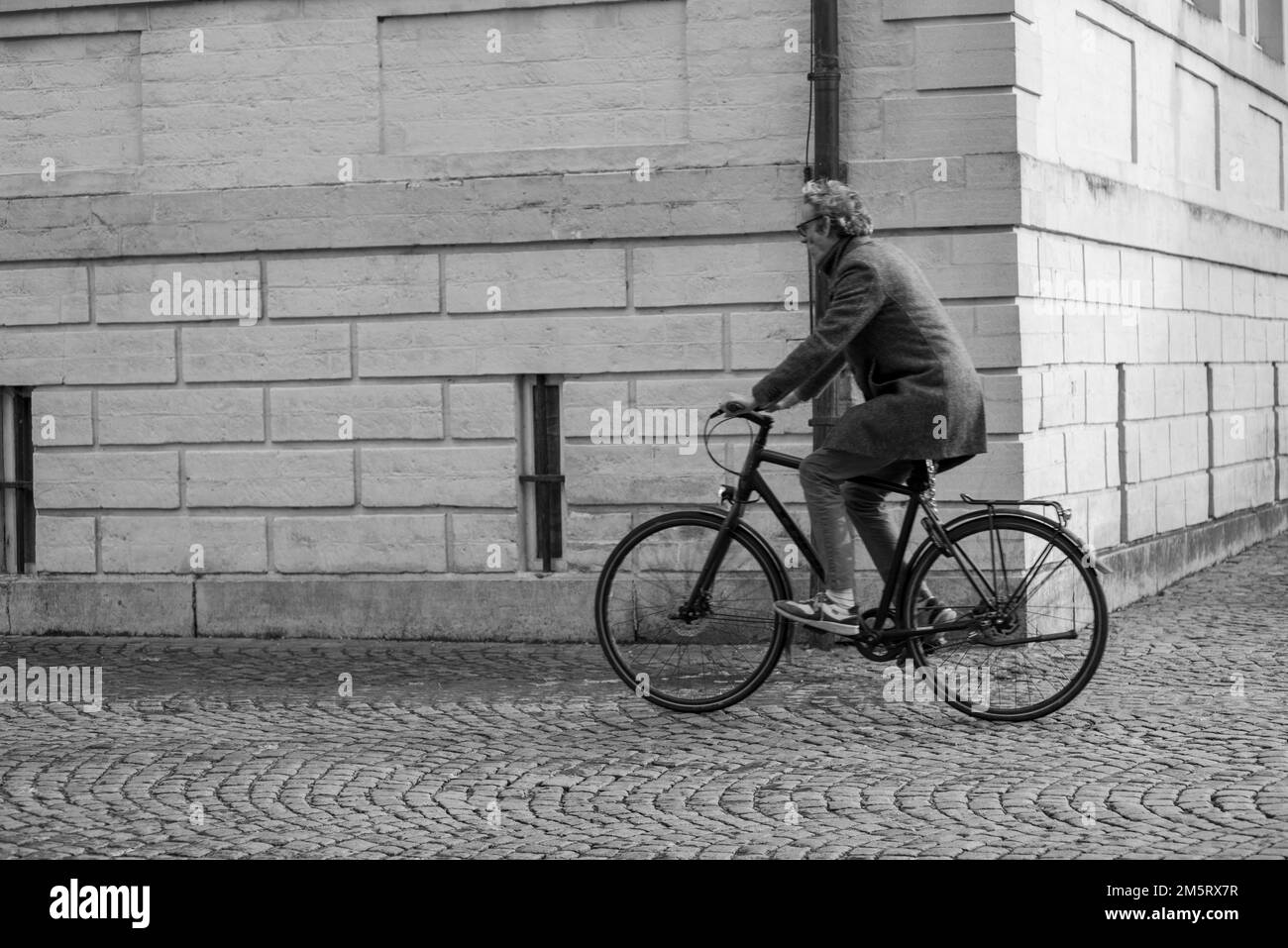 Bruges, Belgio, novembre 20th 2022, donna in bicicletta su strada acciottolata a Bruges Belgio Foto Stock