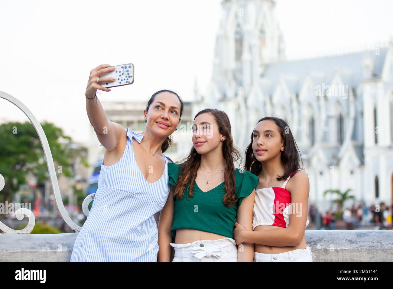 Turisti che prendono un selfie al Ponte di Ortiz con la chiesa la Ermita sullo sfondo nella città di Cali in Colombia Foto Stock