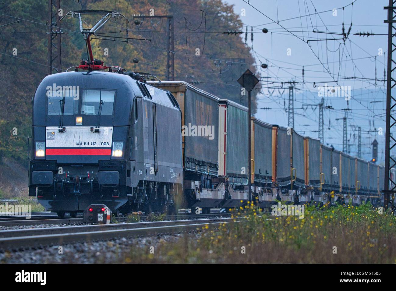 Una locomotiva Siemens TAURUS di classe 182 (182 508) di MRCE guida un treno merci con semirimorchi attraverso Gemuenden. Foto Stock