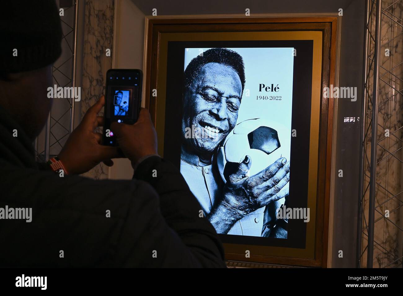 New York, Stati Uniti. 30th Dec, 2022. Un uomo usa il suo cellulare per catturare un'immagine del leggendario giocatore brasiliano di calcio Pele all'interno del negozio di Pele Soccer a Times Square, dopo la notizia della sua morte, New York, NY, 30 dicembre 2022. Conosciuto come Pele, Edson Arantes do Nascimento è morto a 82 anni dal cancro il 29 dicembre, ed è considerato come un'icona dello sport del calcio. (Foto di Anthony Behar/Sipa USA) Credit: Sipa USA/Alamy Live News Foto Stock